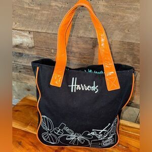 Harrods black canvas tote with orange paten leather trim and handles snap close